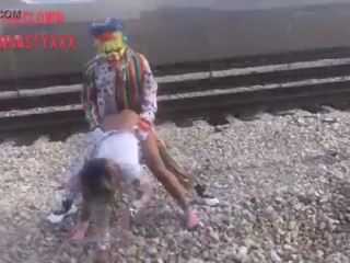 Clown fucks young lady on train tracks
