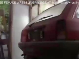 Două fete luptă în o masina junkyard